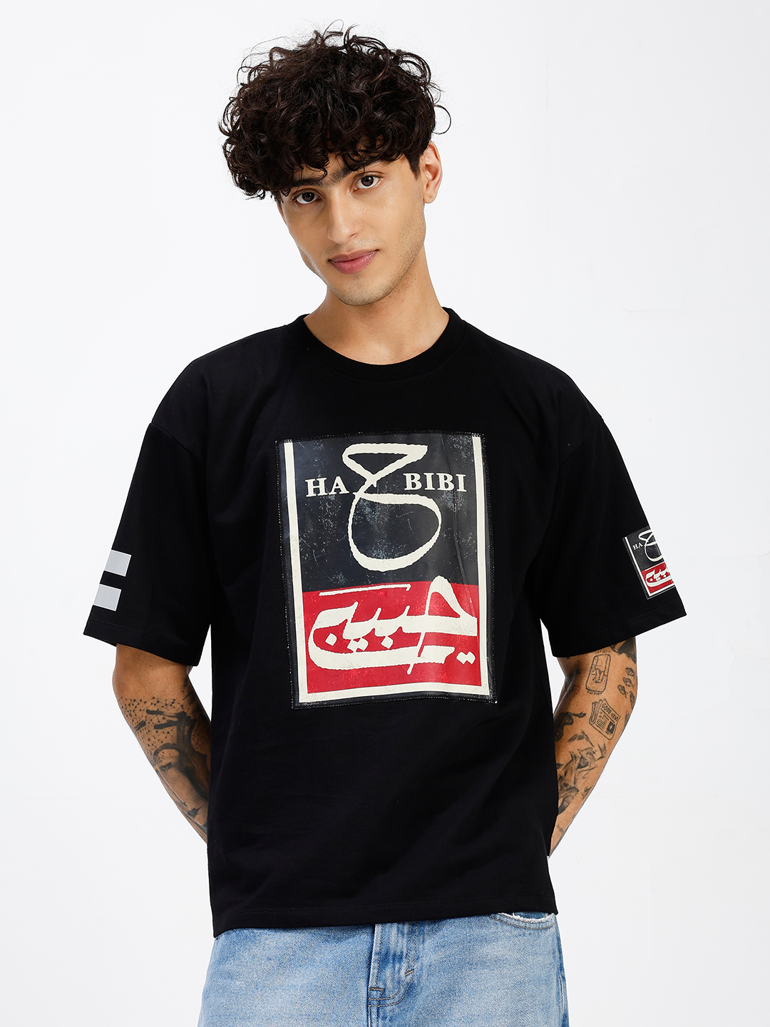 HABIBI oversized black T-shirt front view showing split black and red Nastaliq calligraphy patch with distressed finish